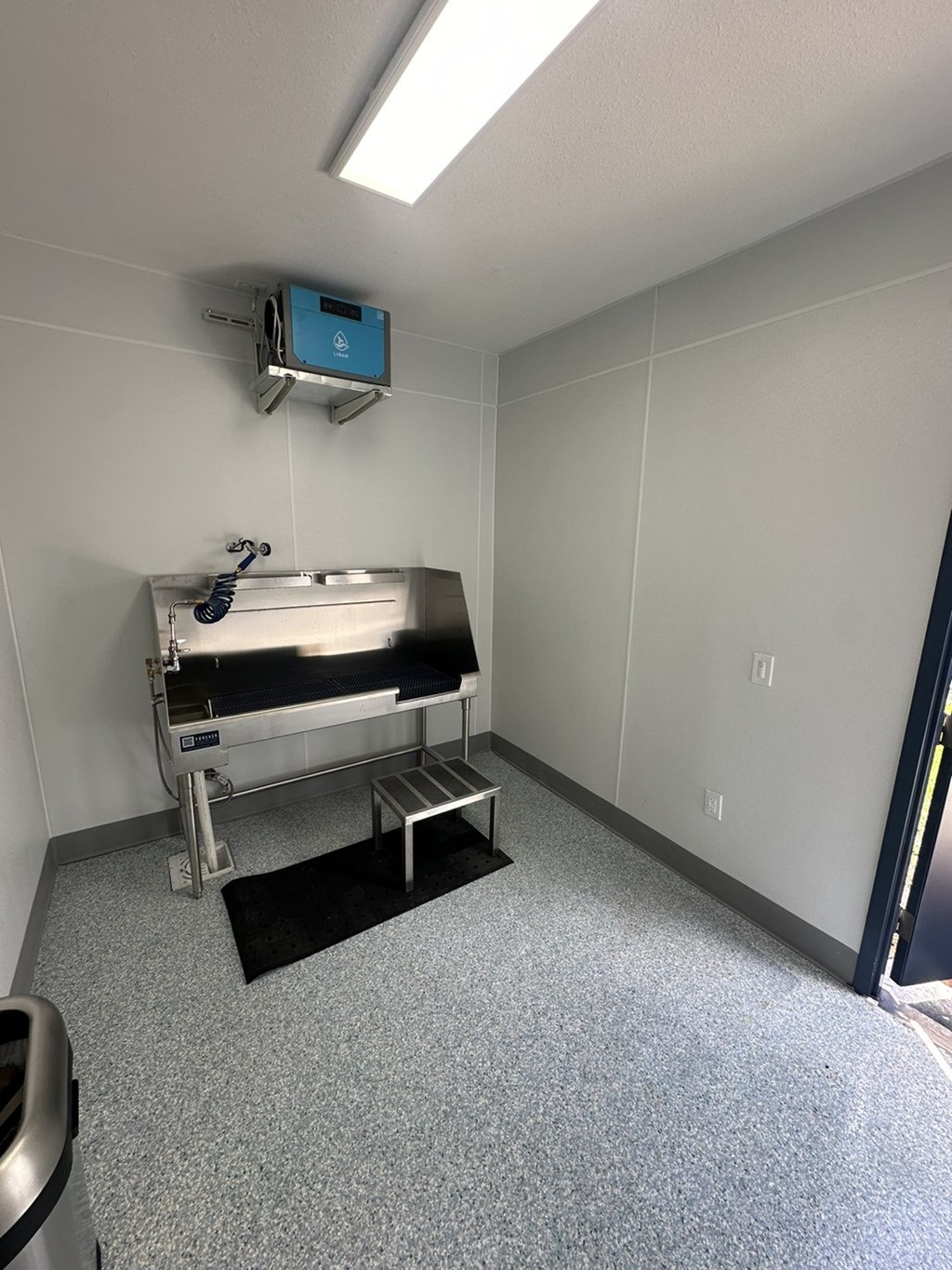 a patient room with a sink and a mirror